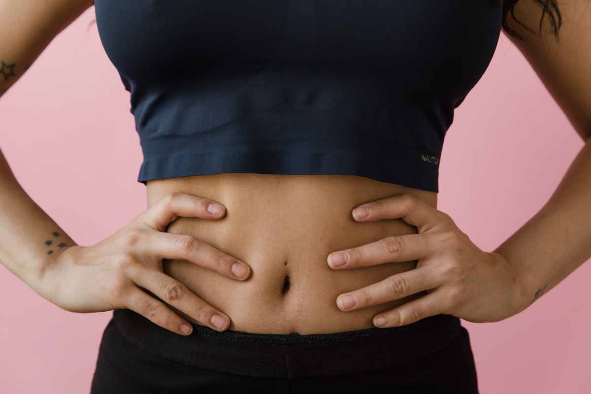 donna con mani sulla pancia simbolo degli alimenti che sgonfiano