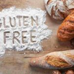 scritta gluten free sulla farina e tipi di pane su un tavolo