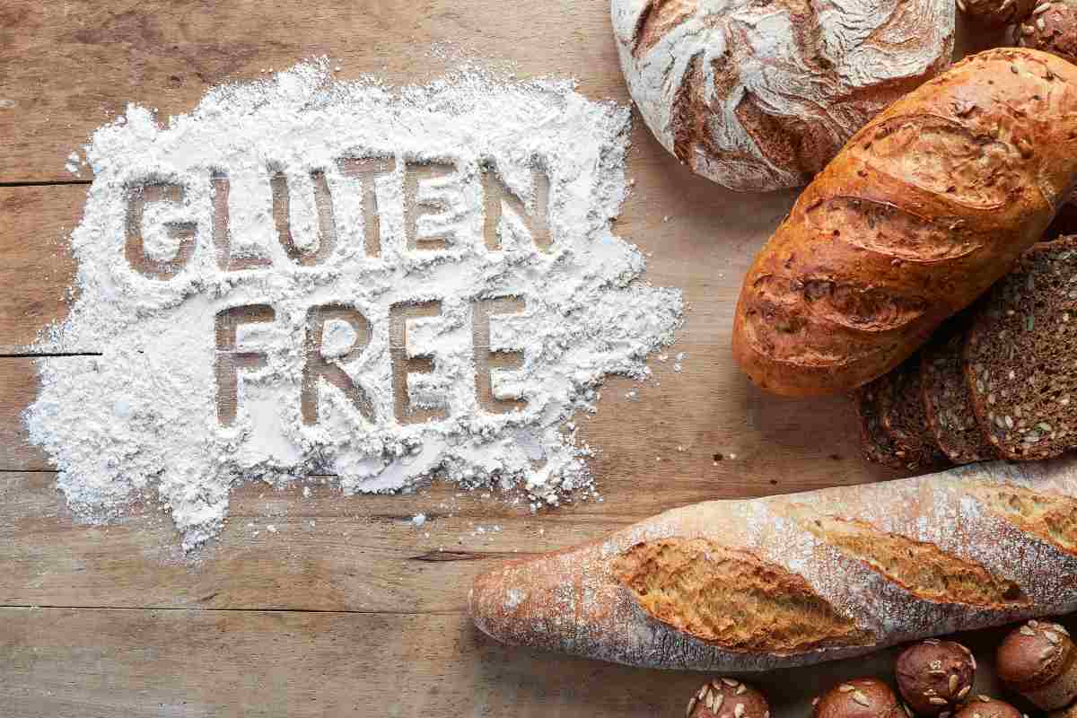 scritta gluten free sulla farina e tipi di pane su un tavolo